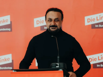 Edis_2 Foto von Mirze Edis vor Leinwand mit "Die Linke" Branding